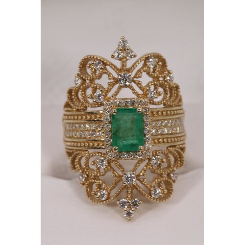 126 - Impressive 14k Gold ring set with centre emerald and surrounded with smaller diamonds.