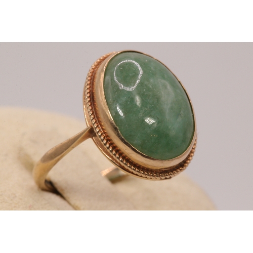 136 - A 9ct gold ring set with oval jade lozenge,