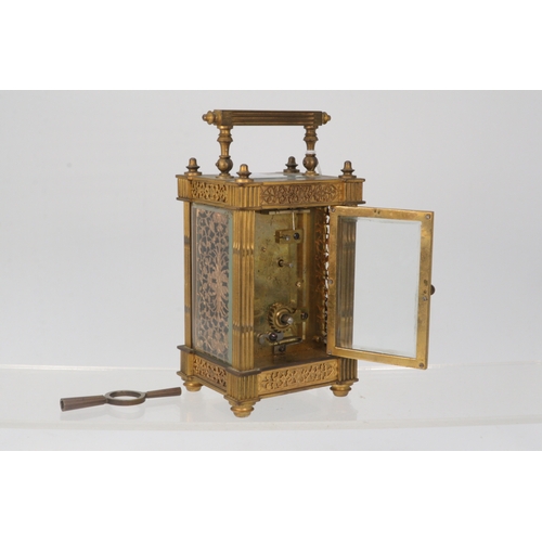 86 - A gilt cased French carriage clock with pierced chased panels and bevelled glass with key (not in wo... 