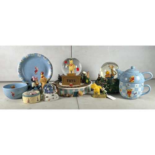 523 - A selection of Winnie-The-Pooh collectables to include Royal Doulton, snow globes etc