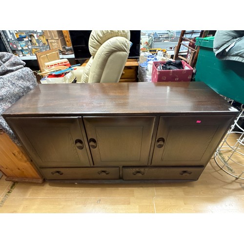 676 - An Ercol sideboard with three cupboards with two drawers under on castors