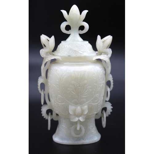 A Chinese jade Lotus vase and cover, 19th/ early 20th century with six free hanging rings, carved in relief with scrolling foliage and Lotus head handles. 14cm to top of cover finial. Cover at fault