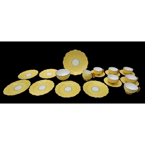 A 1930s Aynsley yellow ground with butterfly tea cup handle detail tea set comprising of biscuit plate, six tea cups, five saucers, six biscuit side plates, sugar bowl and cream jug, all leaf moulded pattern and gilt finish.