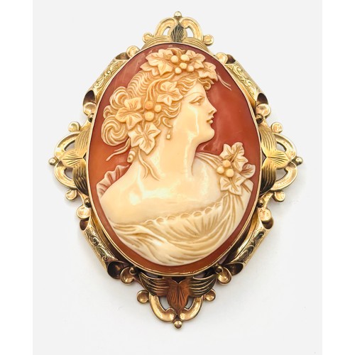 A vintage 9ct gold shell cameo brooch, hallmarked 375 , the oval panel relief carved depicting profile of a lady, surrounded by intricate scroll frame, length approx 7.5cm, with a hinged pin and rotating clasp, total gross weight approx 28gms