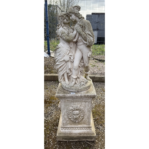 382 - Reconstituted  stone statue of lovers on pedestal adorned with lions Approx. H130cm