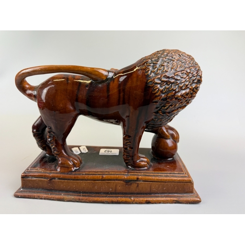 162 - Treacle glazed ceramic lion on plinth - Approx. W30cm H24cm D13cm