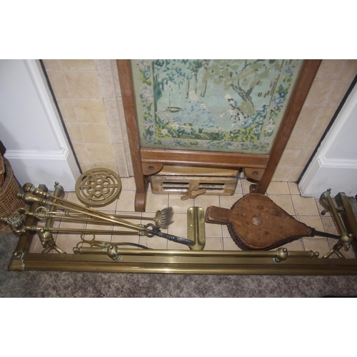 1019 - A Victorian brass fender, fireirons, bellows and firescreen