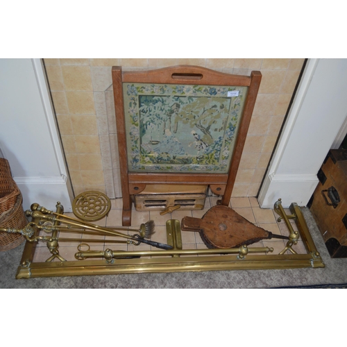 1019 - A Victorian brass fender, fireirons, bellows and firescreen