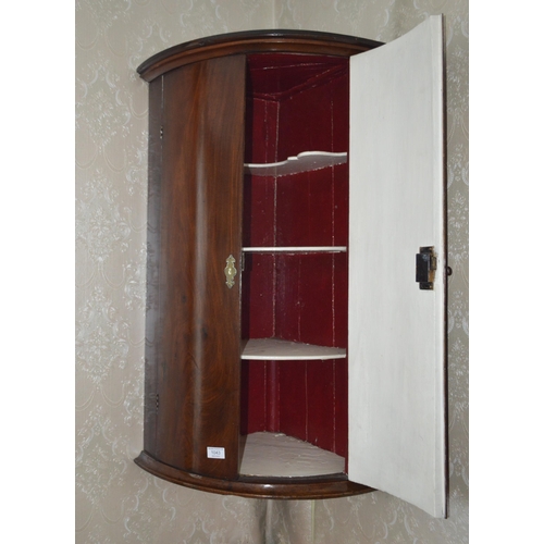 1043 - An early 19th Century mahogany two door bow fronted corner cupboard, width 24