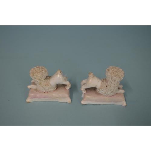 133 - Early 19th Century Staffordshire porcelain poodles on cushion bases, 2 3/4