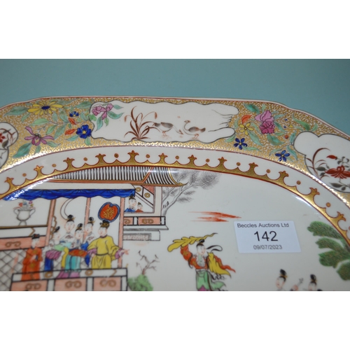 142 - An 18th Century porcelain platter in the Chinese manner, hand painted with figures, floral border wi... 