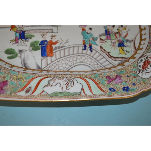 142 - An 18th Century porcelain platter in the Chinese manner, hand painted with figures, floral border wi... 