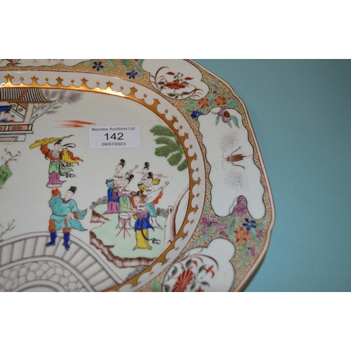 142 - An 18th Century porcelain platter in the Chinese manner, hand painted with figures, floral border wi... 