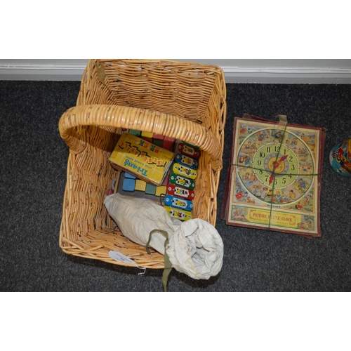 16 - A basket of vintage children's games including picture puzzle clock, Tri-ang colour spell bricks, a ... 