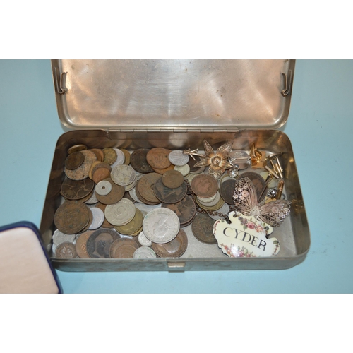 184 - A tin of various GB and world coins plus a few white metal brooches and an enameled 'Cyder' decanter... 