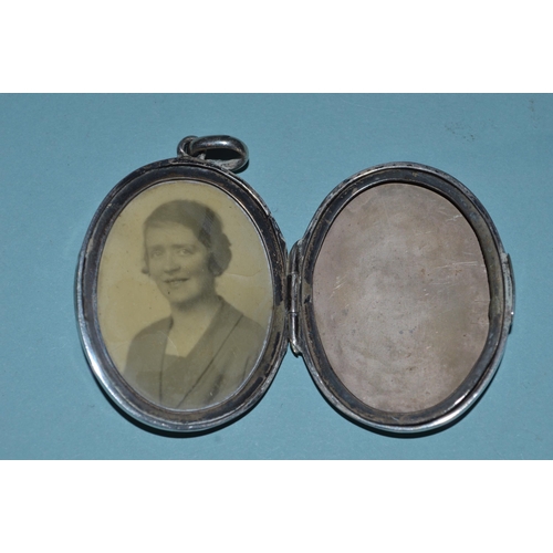 65 - A hallmarked silver locket plus a white metal and enamel smaller example