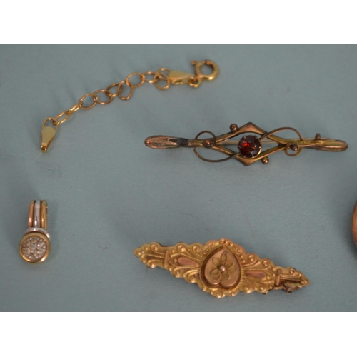 73 - A 9ct gold marked brooch (as found), a ruby set brooch, a 9ct gold locket plus a small three colour ... 