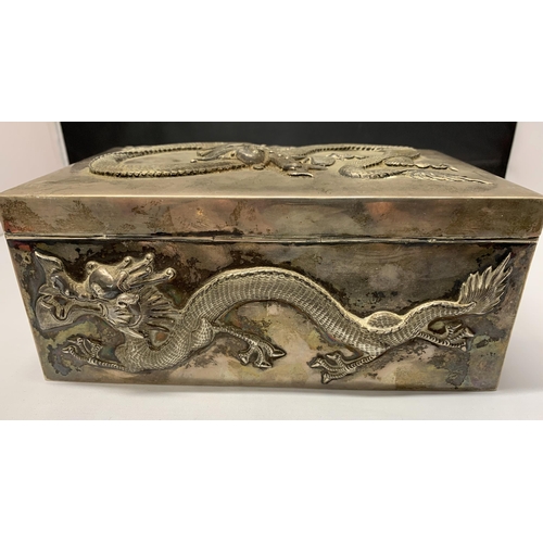 163 - A fine Oriental white metal and wood lined cigar box, elaborately decorated with dragons on all side... 