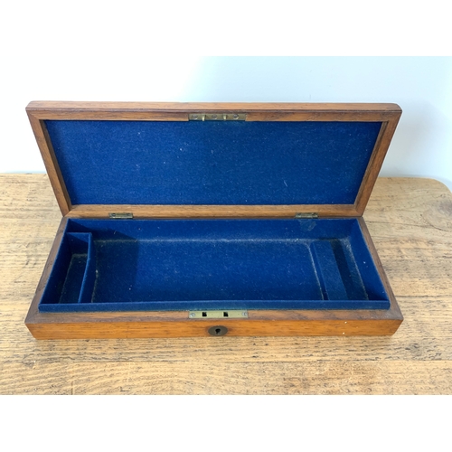 140 - A vintage oak pistol case with brass circle on top reading 'S Baldwin' with blue baize interior