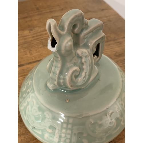 195 - An Oriental celadon glaze lidded jar with animal finial to lid and fixed ring handles, approx. 12 1/... 