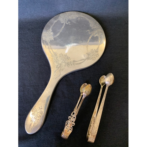 114 - A hallmarked silver mirror (lacking glass) plus two pairs of hallmarked sugar tongs (one marked Ster... 