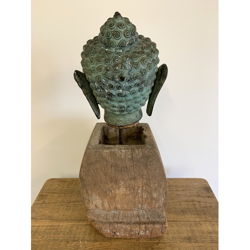 139 - A vintage Thai cast bronze buddha head, a hollow head which sits on a purpose made wood pole, this i... 