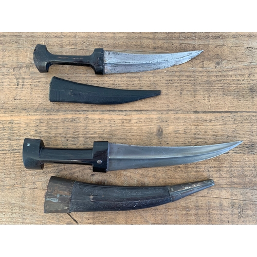 208 - A pair of Middle Eastern hand made Jambiya type knives with bone handles and leather scabbards, larg... 