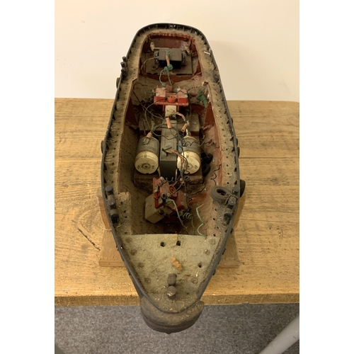 64 - A small vintage remote controlled boat, hull only (inside as found, no controller), 24