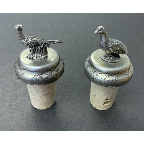 80 - A pair of white metal bottle stoppers, one with a pheasant, the other a partridge