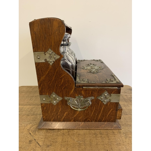 82 - A fine antique oak three bottle Tantalus with mirror back, formally silver plated mounts, Bramah loc... 