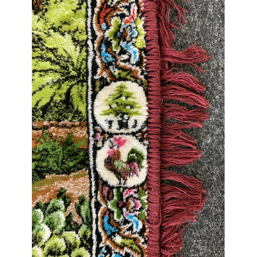 310 - A vintage brightly coloured floor rug with camels by a river, 71