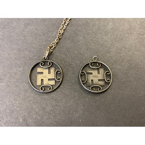 153 - Two silver blue enamelled swastika pendants, one on a chain (one scroll missing)