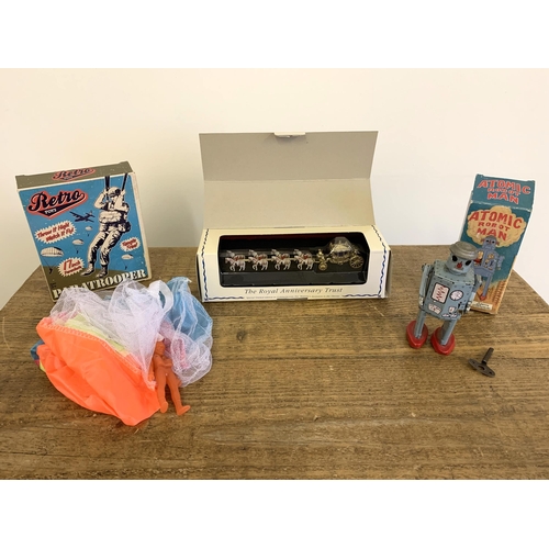 138 - A boxed vintage 1997 'Atomic Robot Man' tin plate robot with key, winds and runs plus a boxed paratr... 