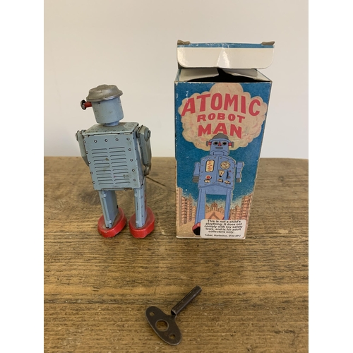 138 - A boxed vintage 1997 'Atomic Robot Man' tin plate robot with key, winds and runs plus a boxed paratr... 