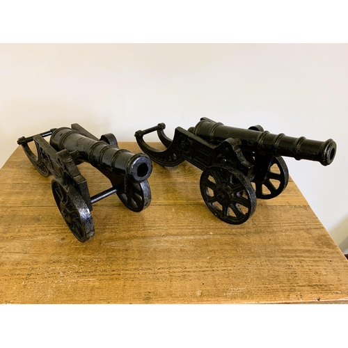 161 - A pair of cast iron black painted cannons with rotating wheels and moveable barrels, approx. 17