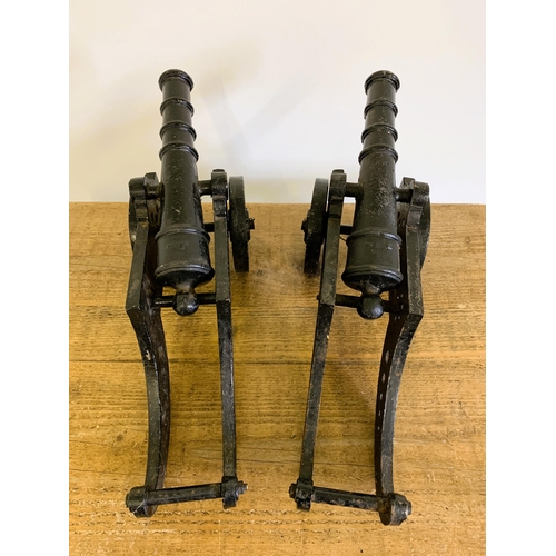 161 - A pair of cast iron black painted cannons with rotating wheels and moveable barrels, approx. 17