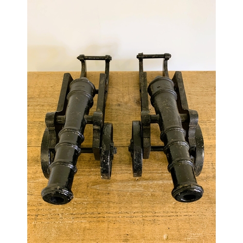 161 - A pair of cast iron black painted cannons with rotating wheels and moveable barrels, approx. 17