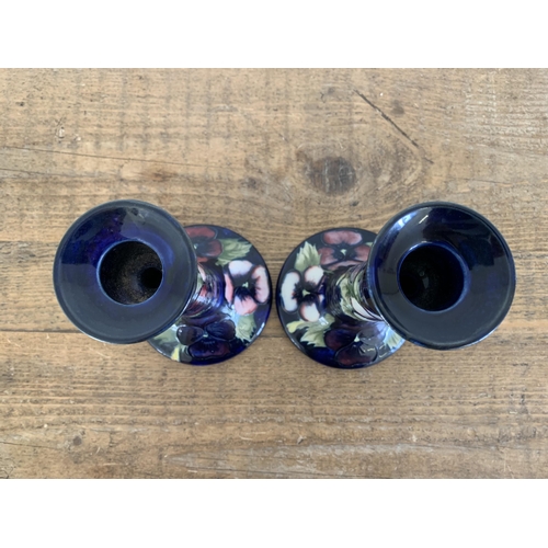 278 - A matched pair of Moorcroft pansy pattern candlesticks, blue signature and label to base, approx. 7 ... 