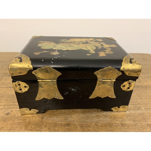 332 - A vintage Chinese black lacquer jewellery box inlaid with mother of pearl and brass ornamentation, t... 