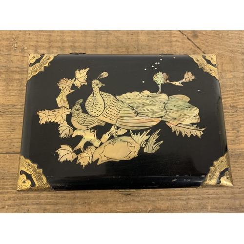 332 - A vintage Chinese black lacquer jewellery box inlaid with mother of pearl and brass ornamentation, t... 