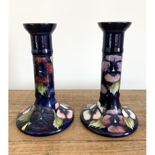 278 - A matched pair of Moorcroft pansy pattern candlesticks, blue signature and label to base, approx. 7 ... 