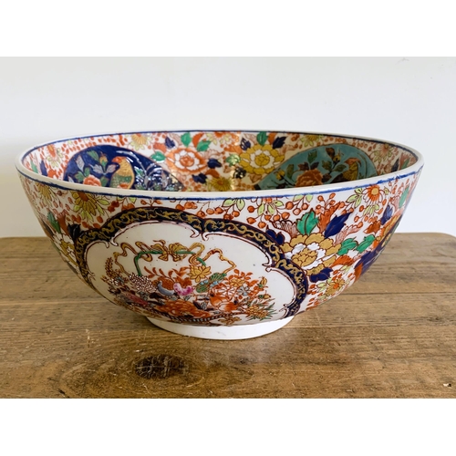 237 - A large hand painted Oriental punch bowl decorated with birds and flowers, Oriental characters to ba... 