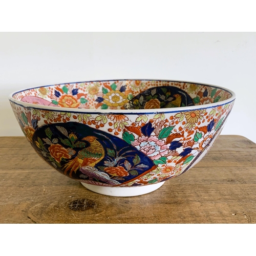 237 - A large hand painted Oriental punch bowl decorated with birds and flowers, Oriental characters to ba... 