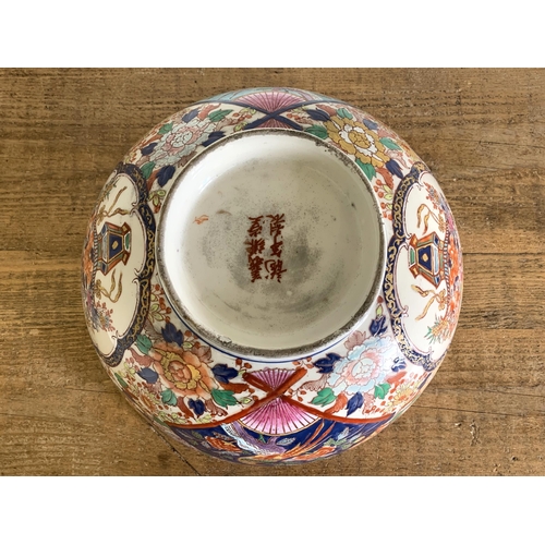 237 - A large hand painted Oriental punch bowl decorated with birds and flowers, Oriental characters to ba... 