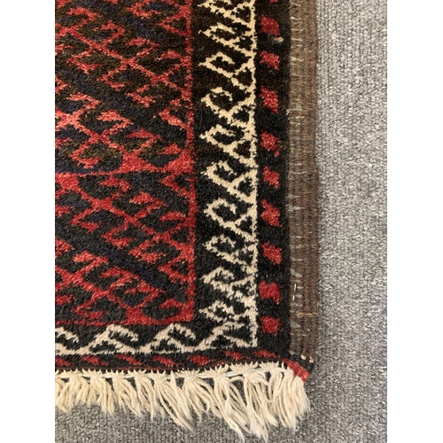 305 - A vintage red ground Belouch floor rug, 76