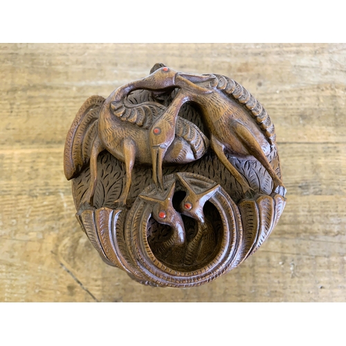 40 - A possibly Indian carved wood lidded bowl decorated with birds, approx. 9