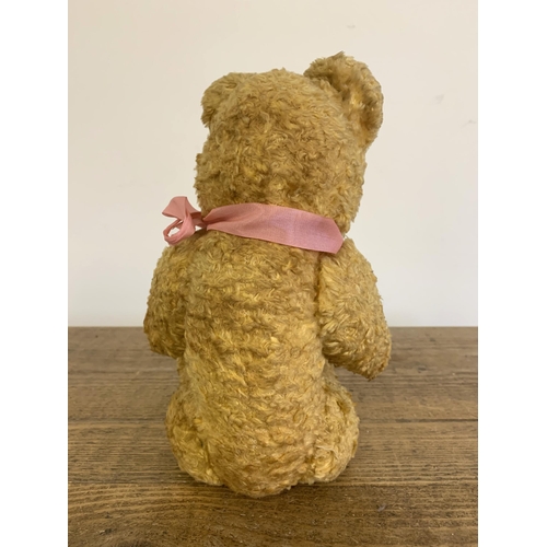 64 - A vintage straw stuffed Teddy bear with glass eyes, approx. 13