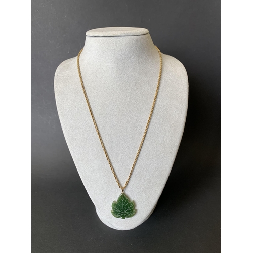 106 - A green stone pendant on chain, the chain is marked 14K on the jump ring and scratch marked 15C on t... 