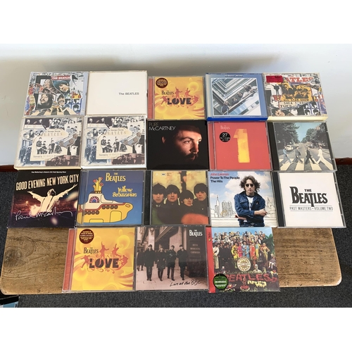 155 - A mixed lot of Beatles collectables including CD's, book and calendar, two 2005 Apple stores tea shi... 