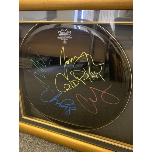 252 - A framed 'Remo Weatherking Ebony Ambassador' drumskin signed by Coldplay in gilt framed case, carrie... 